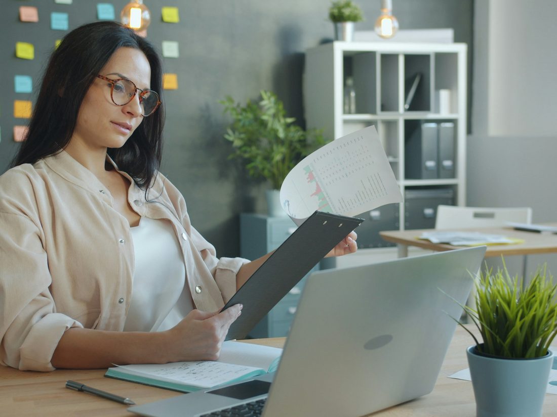 An educator reviewing a stack of paperwork at a desk